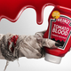 Zombie hand holding out bottle of Tomato Blood ketchup